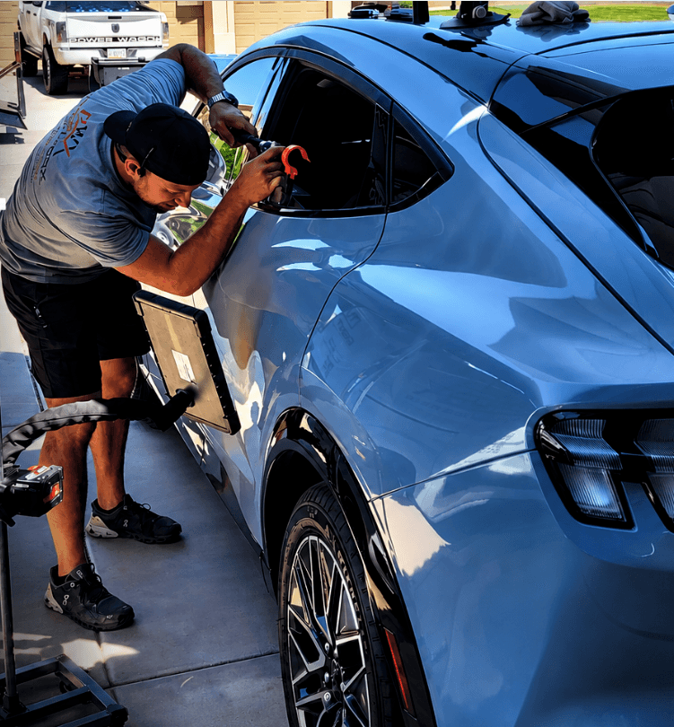 Jordan from DentWorx performing paintless dent repair on a vehicle.
